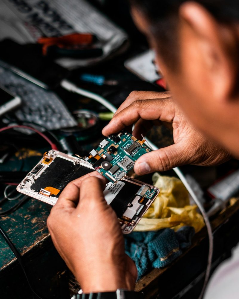 Kỹ thuật viên sửa điện thoại tại bàn làm việc